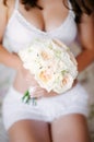 Bride in white lingerie holds a wedding bouquet closeup Royalty Free Stock Photo