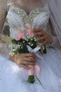 bride in a white wedding dress with a bouquet of flowers, . Bridal party wear, neckline beads on the bodice,veil Royalty Free Stock Photo