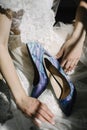 Bride in a white wedding dress holding wedding shoes in her hands Royalty Free Stock Photo