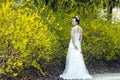 A bride with white wedding dress stand by Golden jasmine flowers Royalty Free Stock Photo