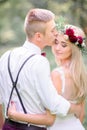 Bride in wine wreathe looks over groom`s shoulder Royalty Free Stock Photo