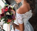 the flower holding by bride neare the window