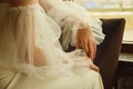 Bride& x27;s hands in a wedding dress. The bride sits leaning on the back of the chair. Royalty Free Stock Photo
