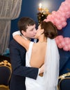 Bridegroom and bride kiss