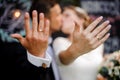 Bridegroom and bride kissing and showing wedding rings on their fingers Royalty Free Stock Photo