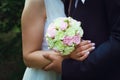 The bridegroom embraces the bride on her wedding day. The bride`s bouquet. Close-up Royalty Free Stock Photo