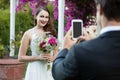 Bridegroom photographing bride holding bouquet at park Royalty Free Stock Photo