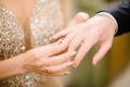 The bridegroom puts the wedding ring on the bride close up. The bride puts the bridegroom on the wedding ring Royalty Free Stock Photo