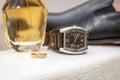 Bridegroom`s wedding ring, perfume, watch and black leather shoe