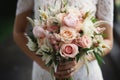 Brides hands adorned with David Austin bouquet, a fragrant emblem of loves union