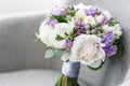 Brides wedding bouquet with peonies, freesia and other flowers on black arm chair. Light and lilac spring color. Morning