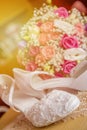 Brides wedding shoes with a bouquet with roses and other flowers.