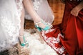 Bridesmaid helps to bride to put wedding shoes. Royalty Free Stock Photo