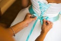 Bridesmaid helps to tie a bow on a festive white dress of the bride on the wedding day Royalty Free Stock Photo