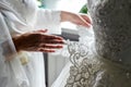 Bridesmaid holding bride`s wedding dress Royalty Free Stock Photo