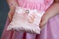 Bridesmaid holds a decorative cushion with wedding gold rings