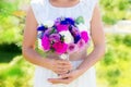 Bridesmaid holds a wedding bouquet of roses in purple tones. Flo