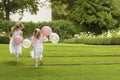 Bridesmaids With Balloons Running In Garden Royalty Free Stock Photo