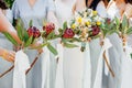 Bridesmaids in blue dresses and bride holding beautiful bouquets of protea flowers. Beautiful luxury wedding blog concept. Royalty Free Stock Photo