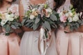 Bridesmaids and bride holding modern wedding bouquets of pink roses and green eucalyptus with pink ribbons. Stylish Contemporary Royalty Free Stock Photo