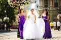 Bridesmaids help bride to put on earrings and necklace