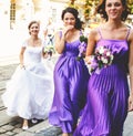 Bridesmaids help bride to put on earrings and necklace