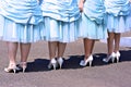 Four pairs of bridesmaids shoes with blue dresses