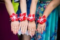 Bridesmaids show bracelets on hands. Bride and bridesmaids with flower bracelets on hands