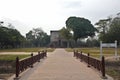 Bridge access to Wat Si Chum complex across moat, with its Giant Buddha visible through a slit in temple wall, Sukhothai, Thailand