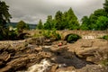 A bridge across falls of Dochart with tourists enjoying the view in a town of Killin Royalty Free Stock Photo