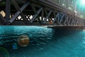 Bridge across water channel. Metal frame structure over pure calm river. Modern urban city landscape with perspective view in Royalty Free Stock Photo