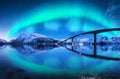 Bridge and aurora borealis over snowy mountains