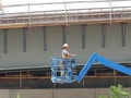 Bridge construction worker on a platform lift