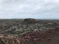 Bridge between continents in Iceland volcanic rock in red and grey forming small volcano