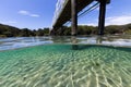 A bridge crosses over beautiful pristine water on a summer day in this underwater split image Royalty Free Stock Photo