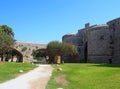 Bridge crossing the amboise gate in the medieval walls of the old city in rhodes town surrounded by grass and trees