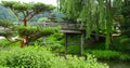 Bridge crossing over a flowing river leading to a Japanese Garden Royalty Free Stock Photo