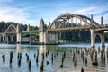 Bridge crossings and river with tree stumps, Florence OR. Royalty Free Stock Photo