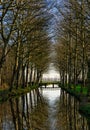 Bridge at the end of a canal surrounded by trees Royalty Free Stock Photo