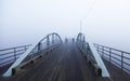 Bridge in fog with cyclists