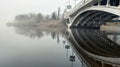 Bridge in the fog. River landscape. Street lights. Royalty Free Stock Photo