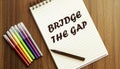 Bridge The Gap. your future target searching, a marker, pen, three colored pencils and a notebook for writing Royalty Free Stock Photo