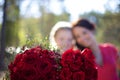 Bridge and her bridesmaid holding up their bouquets of red roses in Norway Royalty Free Stock Photo