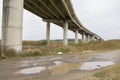 Countryside road passing under a highway bridge