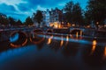 Bridge illumination and boat light trails in evening Amsterdam with reflection in Herengracht canal. Typical dutch Royalty Free Stock Photo