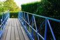 Bridge iron fence in the park with wooden platform and green trees outdoor