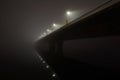 Bridge with lanters in perspectice leading into fog at night