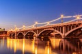 A bridge with lights hanging from it over a river Royalty Free Stock Photo