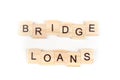 Bridge loans- word composed fromwooden blocks letters on White background, copy space for ad text