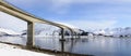 Wide panoramic view of bridge in the Lofoten islands in winter with mountains reflection in fjord.